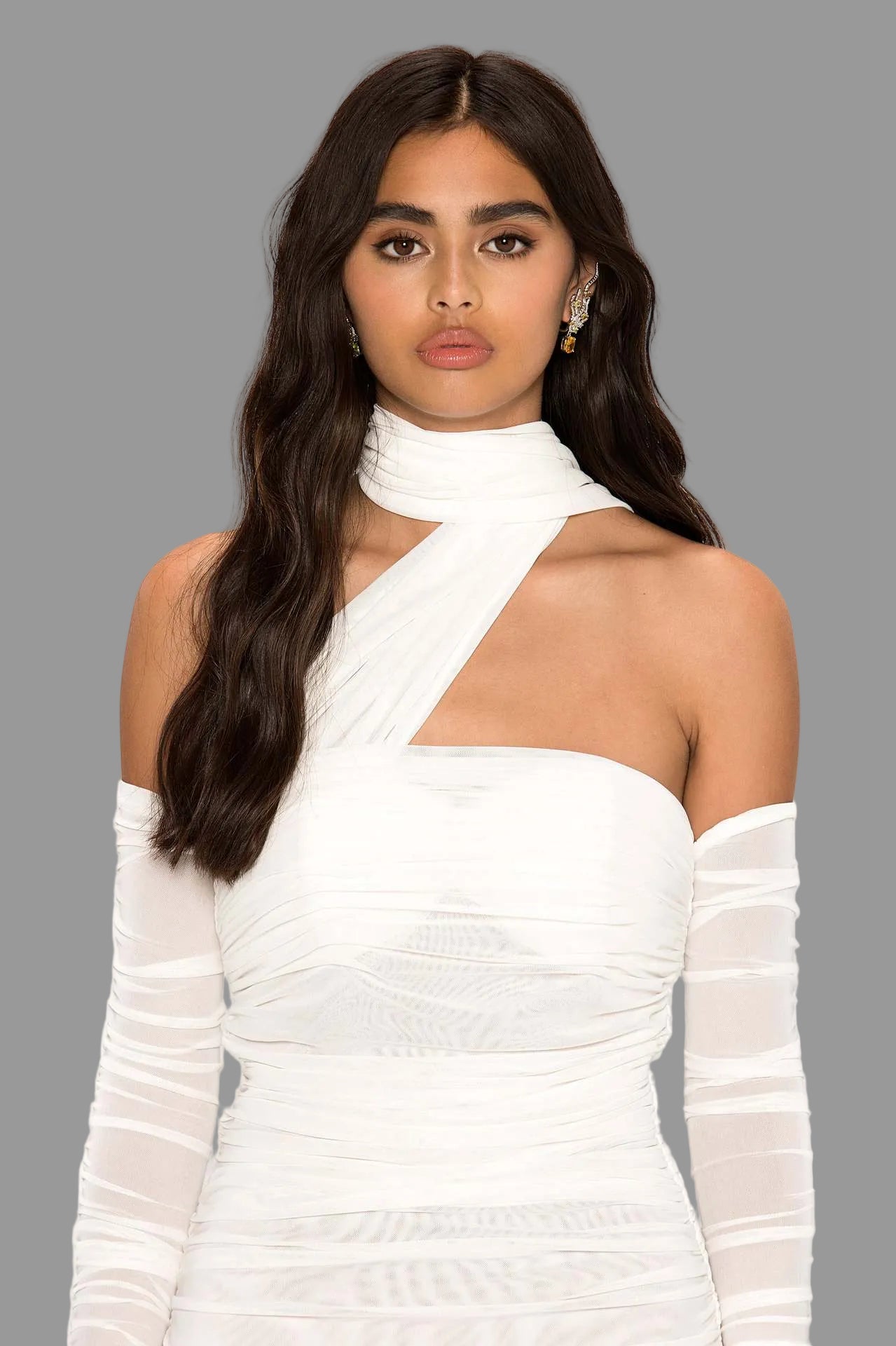 Woman wearing a white dress with sheer sleeves on a white background