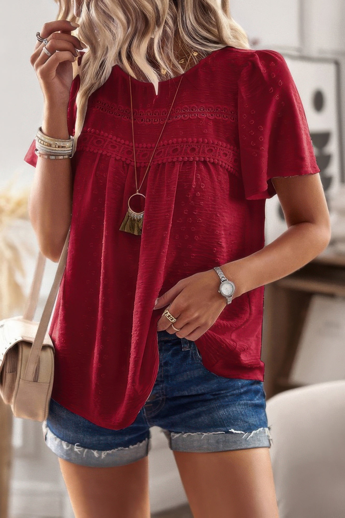 Red plus size solid short sleeve top with lace yoke and flutter sleeves styled with denim shorts