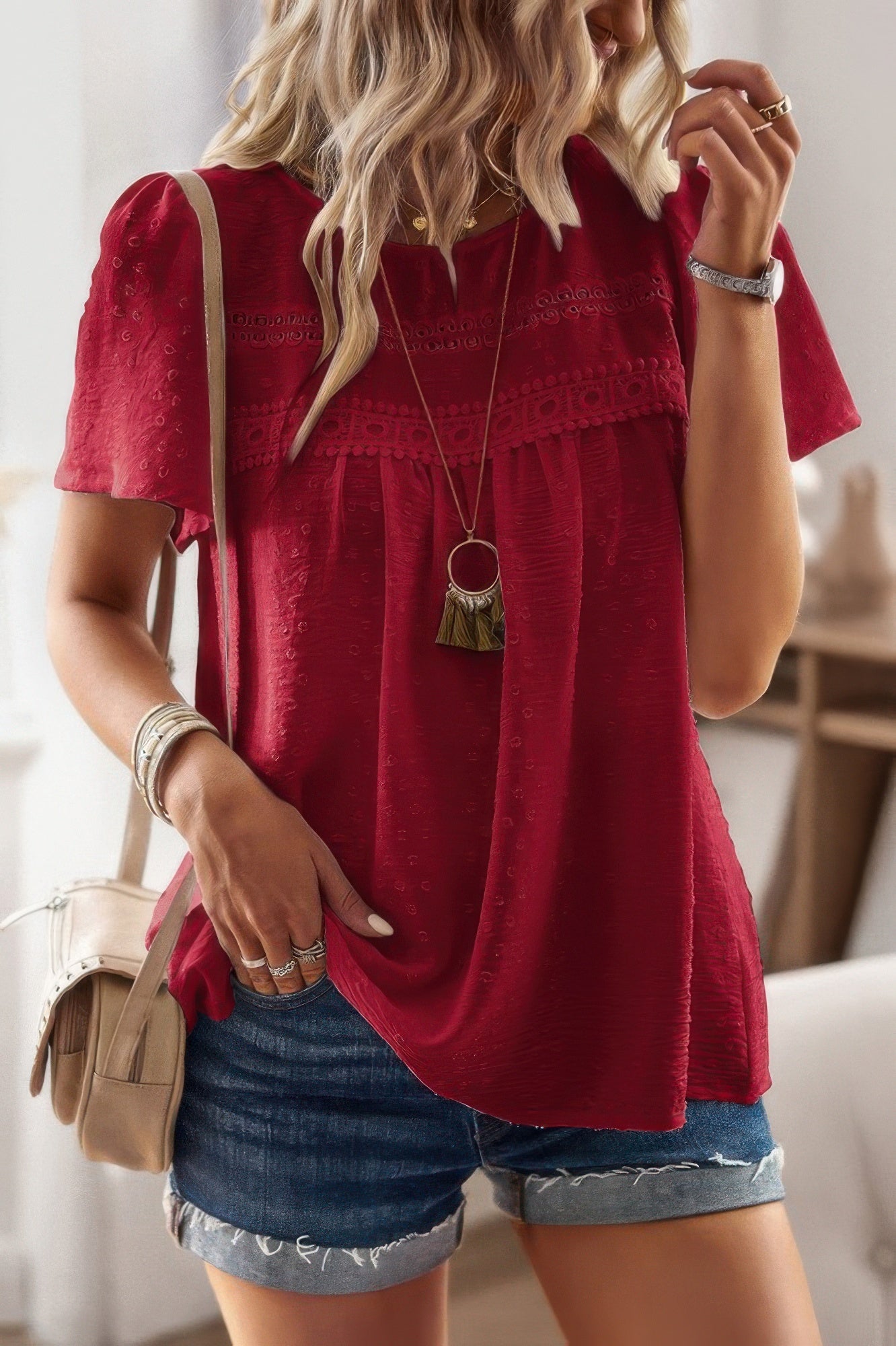 Red plus size solid short sleeve top with lace yoke and textured fabric shown on model with denim shorts and crossbody bag