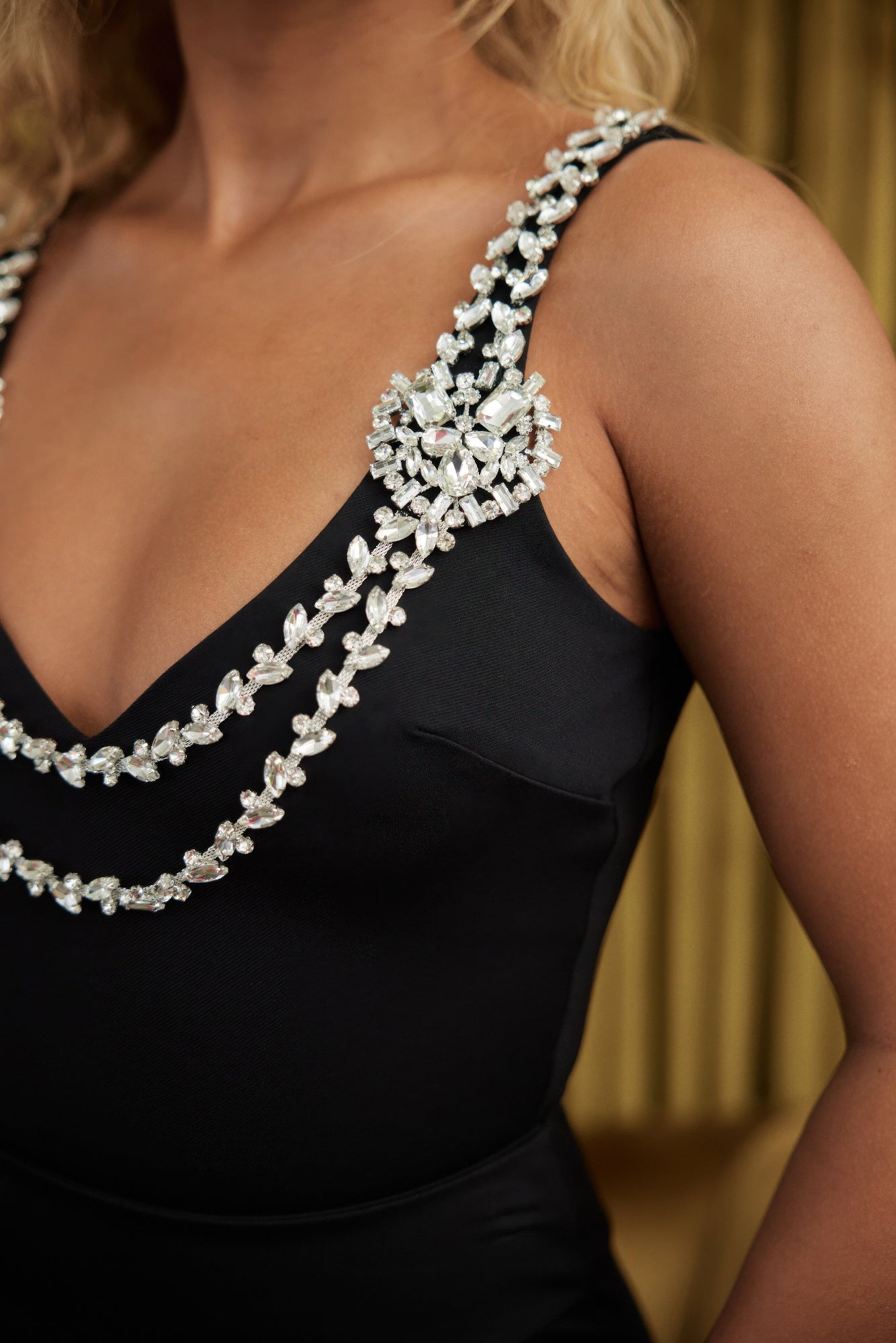 Black layered crystal strap bodysuit with jeweled V neck straps and decorative crystal chains on shoulder