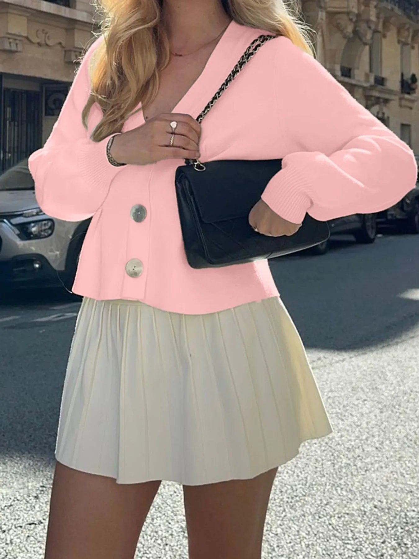 Trendsi women's button-up knit cardigan in soft pink with oversized buttons paired with white pleated skirt