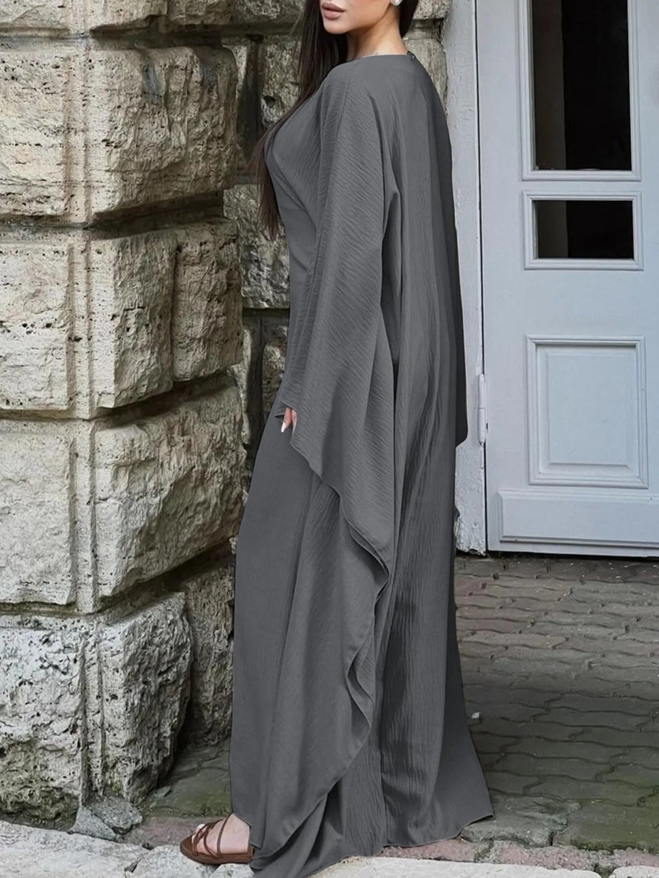 Trendsi model wearing gray bohemian maxi dress with cape sleeves side view flowing lightweight fabric