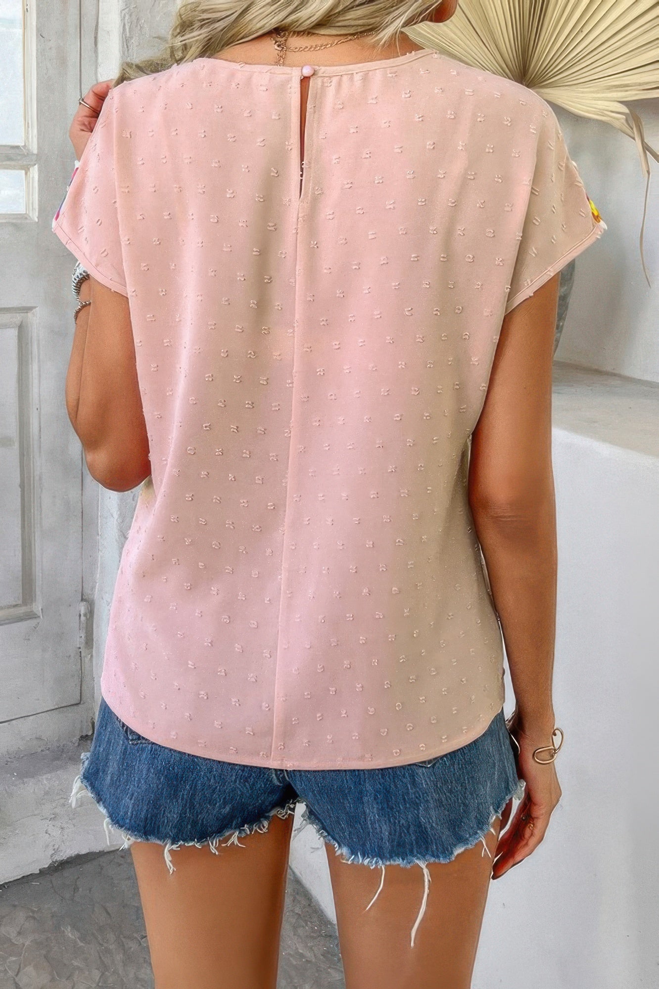 Swiss dot crochet patchwork shirt in blush pink back view with keyhole button and frayed denim shorts