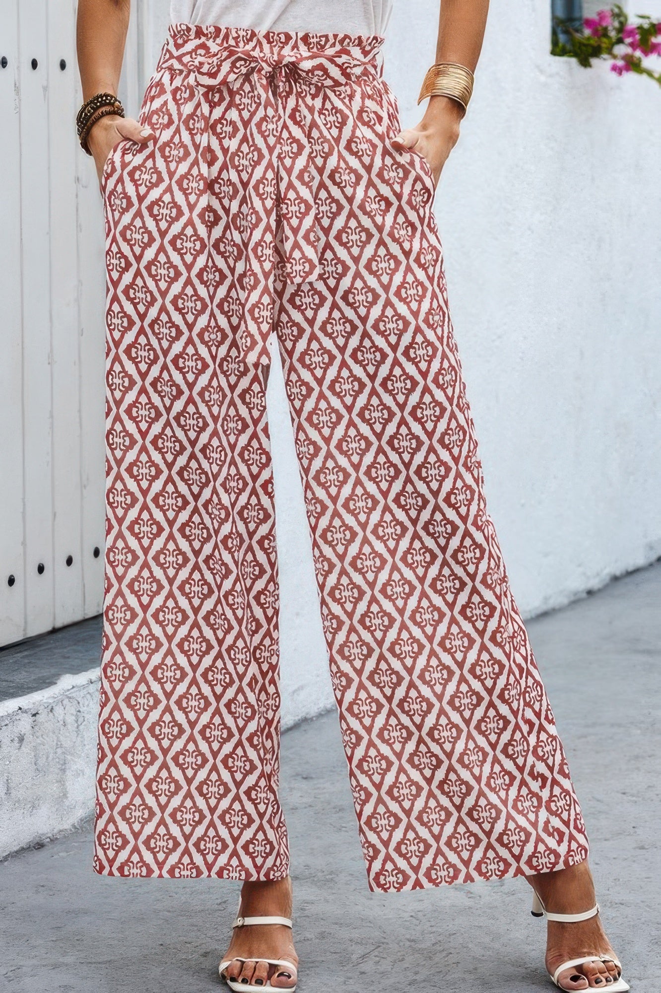 Woman wearing CCWHOLESALECLOTHING Tie Pockets Knot Pants in rust geometric print wide leg with elastic waist and pockets