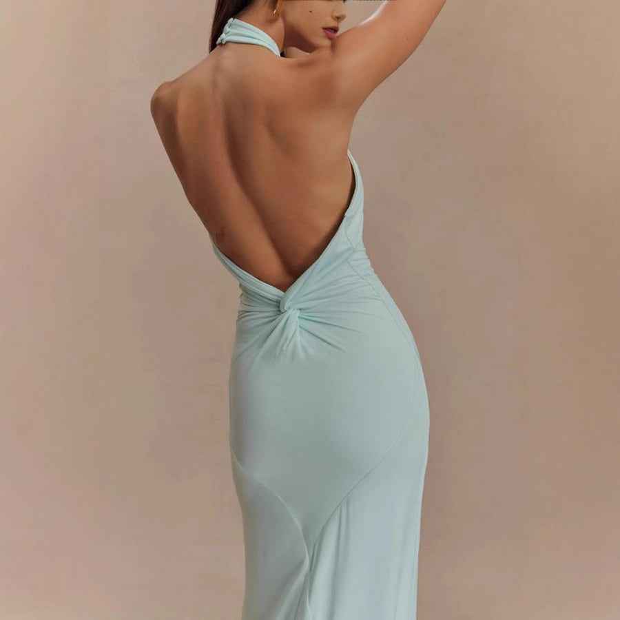 Back view of an elegant formal gown in light blue, showcasing a halter neck design and open back