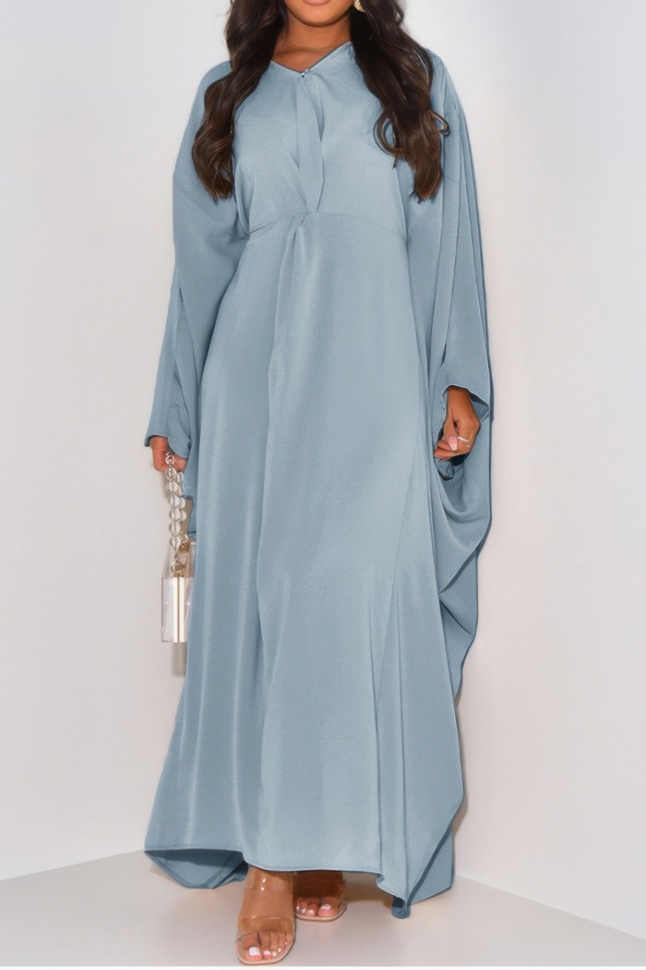 Light blue loose fit v neck maxi dress with long draped sleeves on model holding chain handle bag