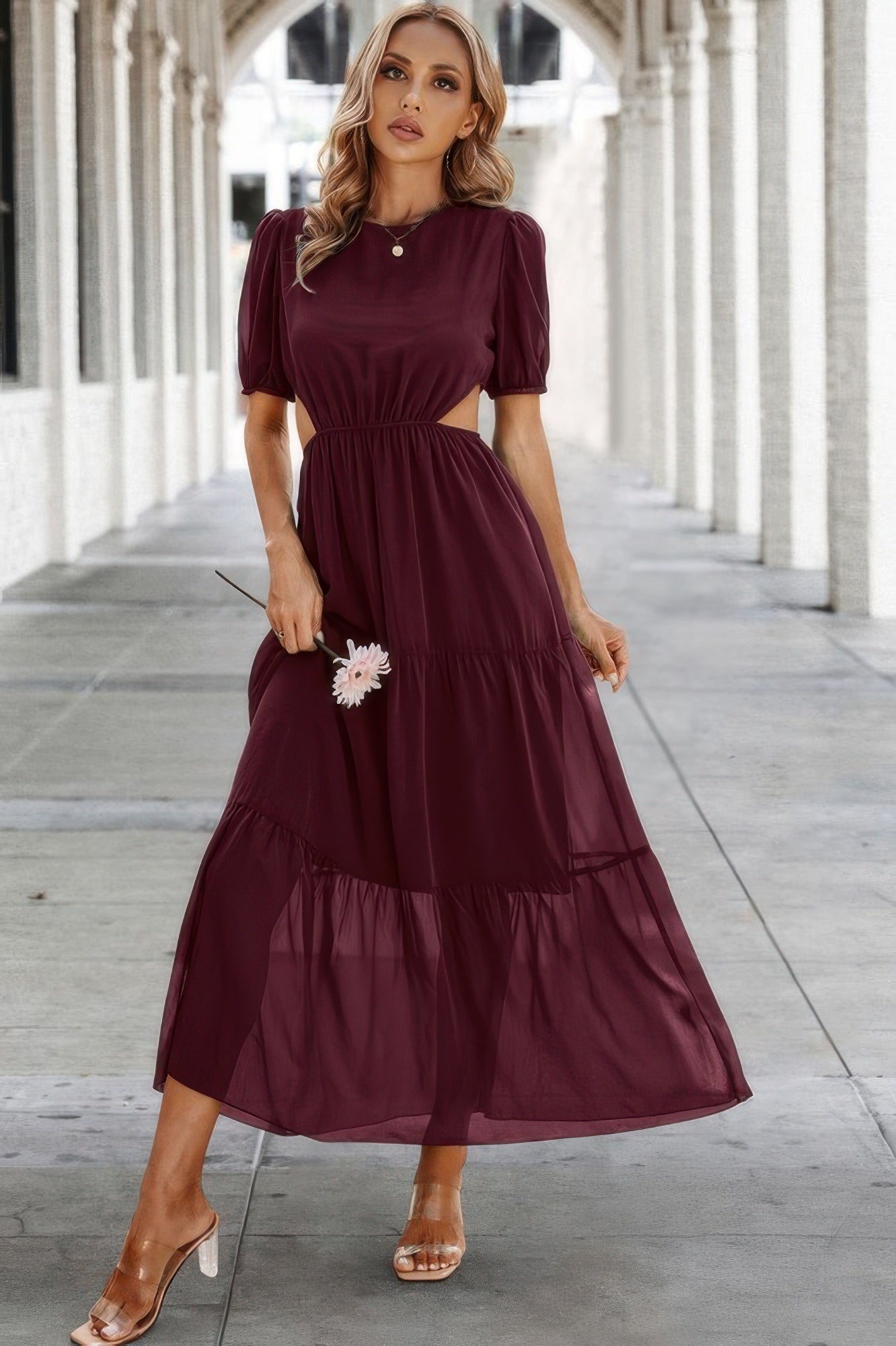 Model wearing burgundy Puff Sleeves Fit Dress with waist cutouts and tiered flowy midi skirt in archway setting