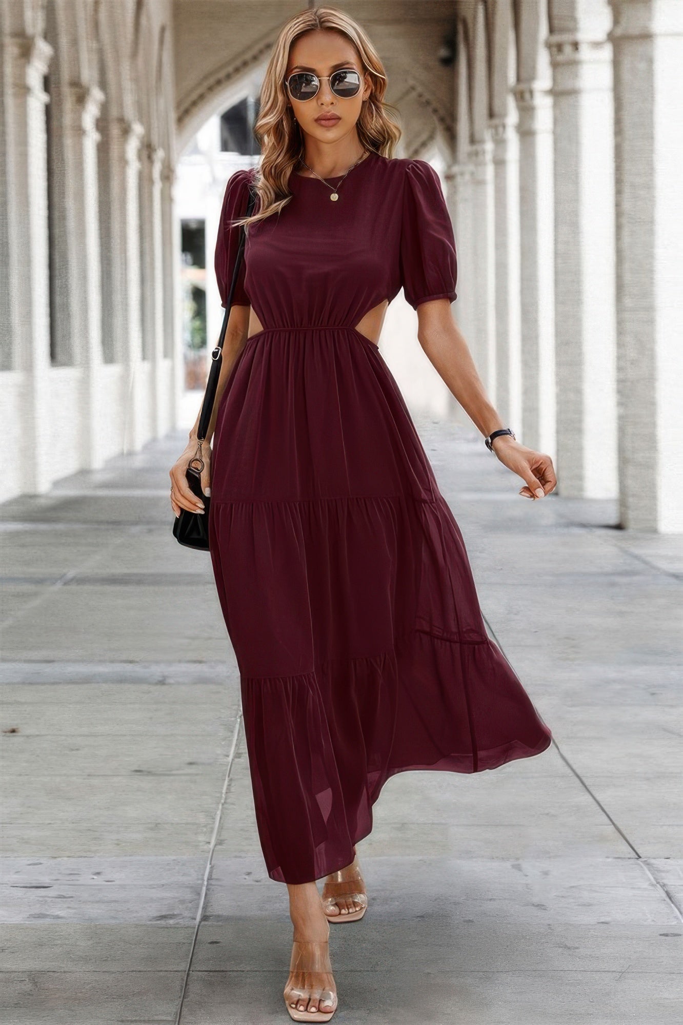 Woman wearing burgundy Puff Sleeves Fit Dress with side cutouts and tiered maxi skirt styled with sandals and sunglasses