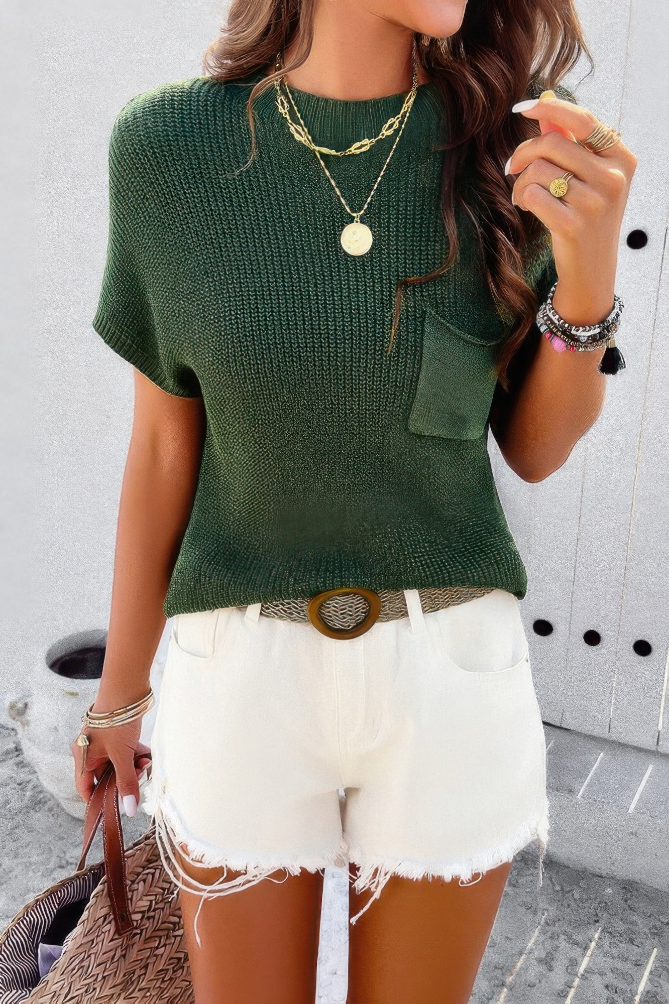 Green ribbed knit loose top with short sleeves and chest pocket paired with white frayed denim shorts