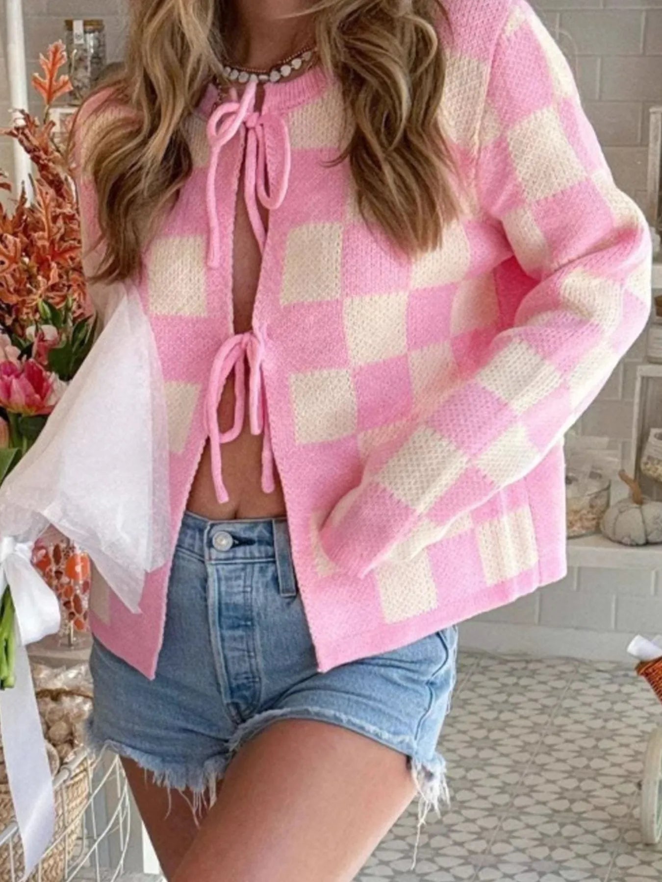 Trendsi pink and cream checker knit Tie-Front Cropped Cardigan with bows shown styled with denim shorts