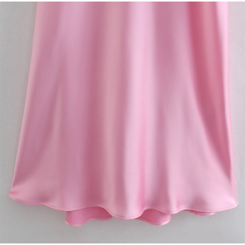 Close-up of pink satin slip dress hem showing smooth and shiny fabric texture