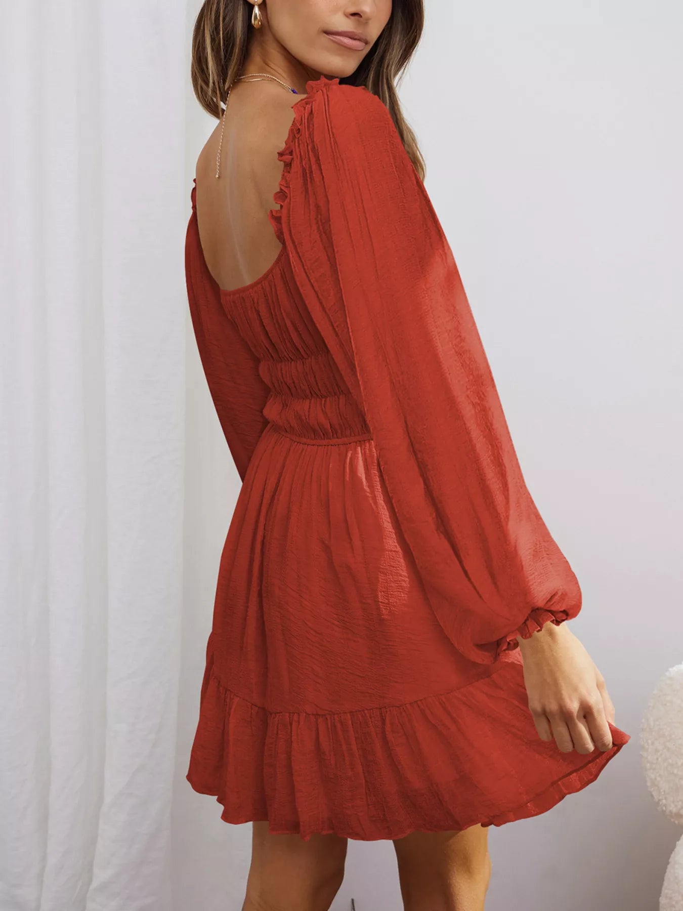 Romantic Flowy Dress in rust color with ruffled hem and long sleeves for a stylish look