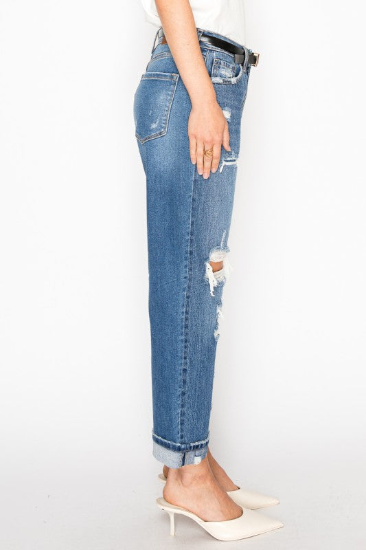 Artemis Vintage model wearing women's hybrid high rise jeans side view cuffed distressed denim with white heels