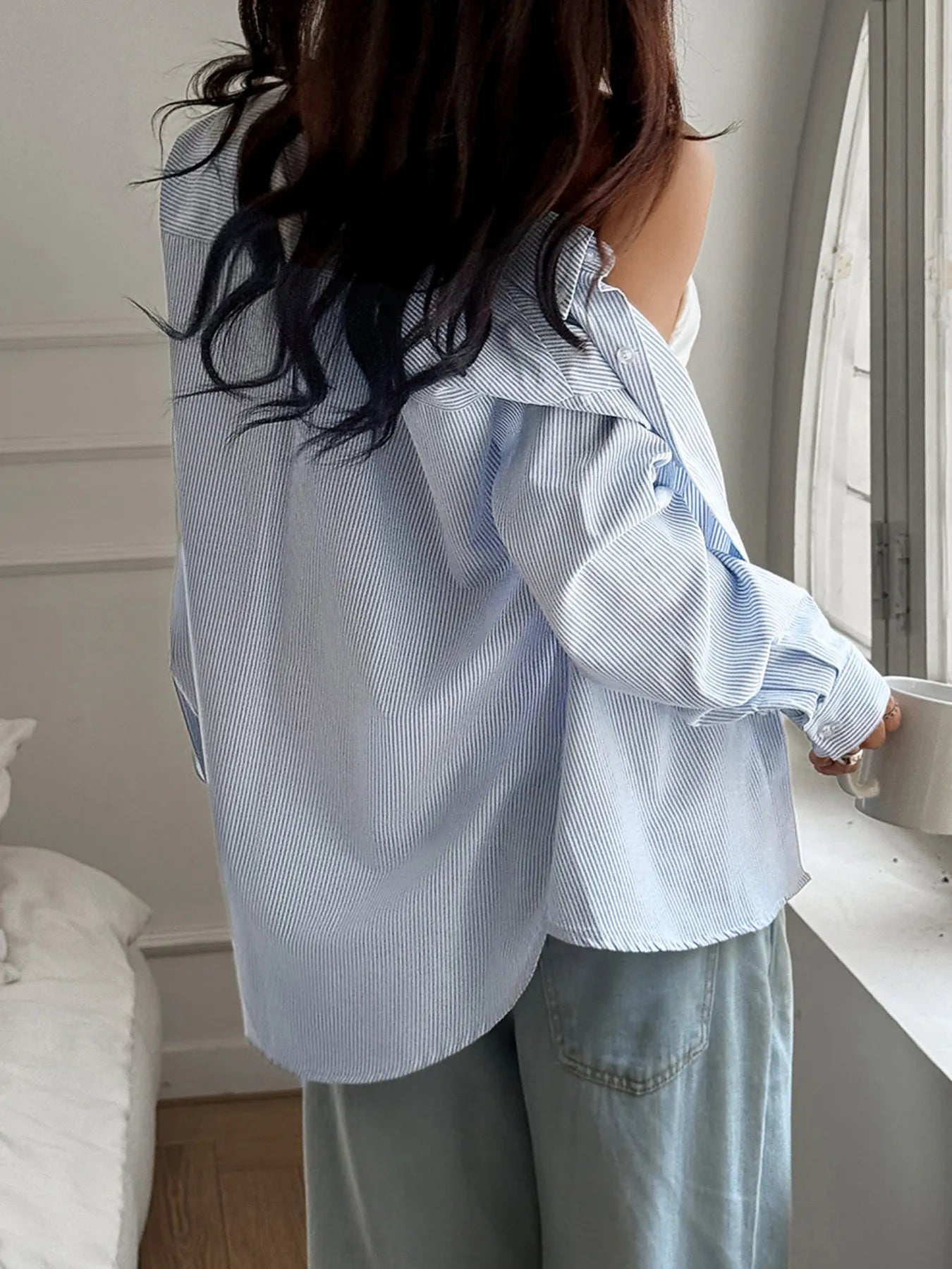 Trendsi striped button-down worn off shoulder with light blue and white stripes styled with casual pants