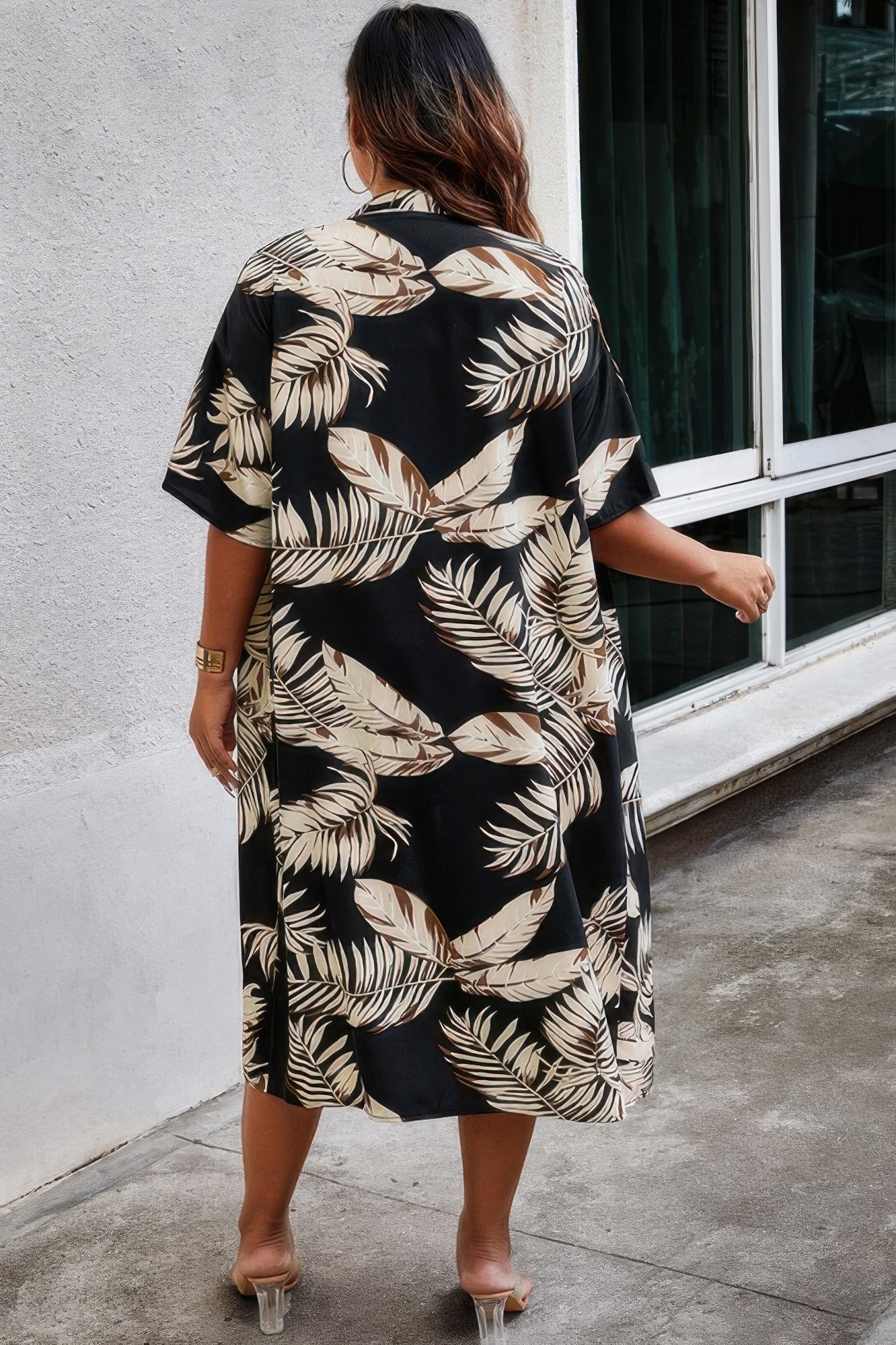 Back view of model in black and beige plus size leaf print shorts set with short sleeve shirt and sandals