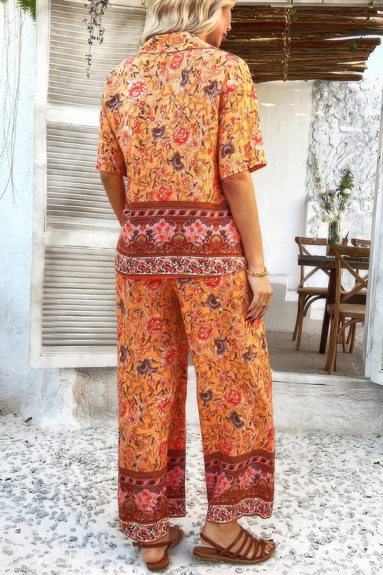 Woman wearing CCWHOLESALECLOTHING Boho Blouse Pant Sets orange floral short sleeve top and wide leg pants
