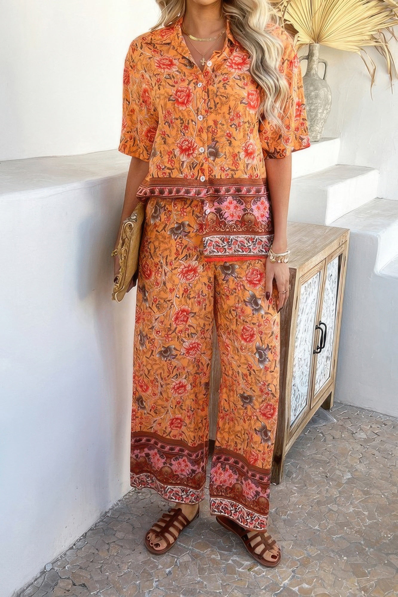 Woman wearing orange floral Boho Blouse Pant Sets with short sleeve button shirt and wide leg pants
