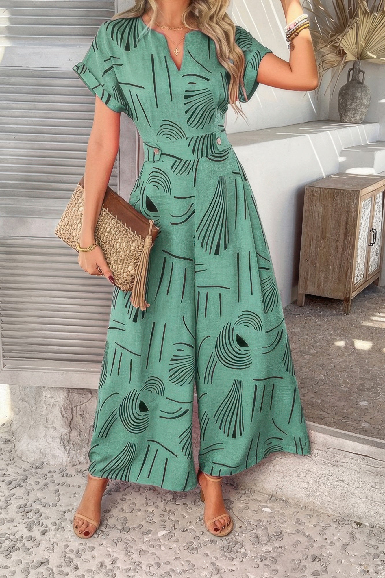Woman wearing green abstract print Tie Waist Pockets Jumpsuit with V neck short sleeves wide legs