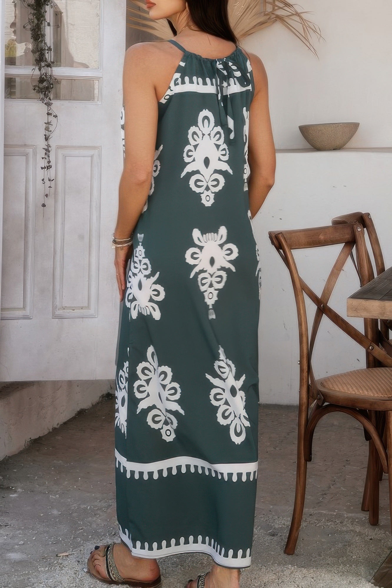 Back view of woman wearing a green geo print halter dress with white motifs ankle length casual summer dress