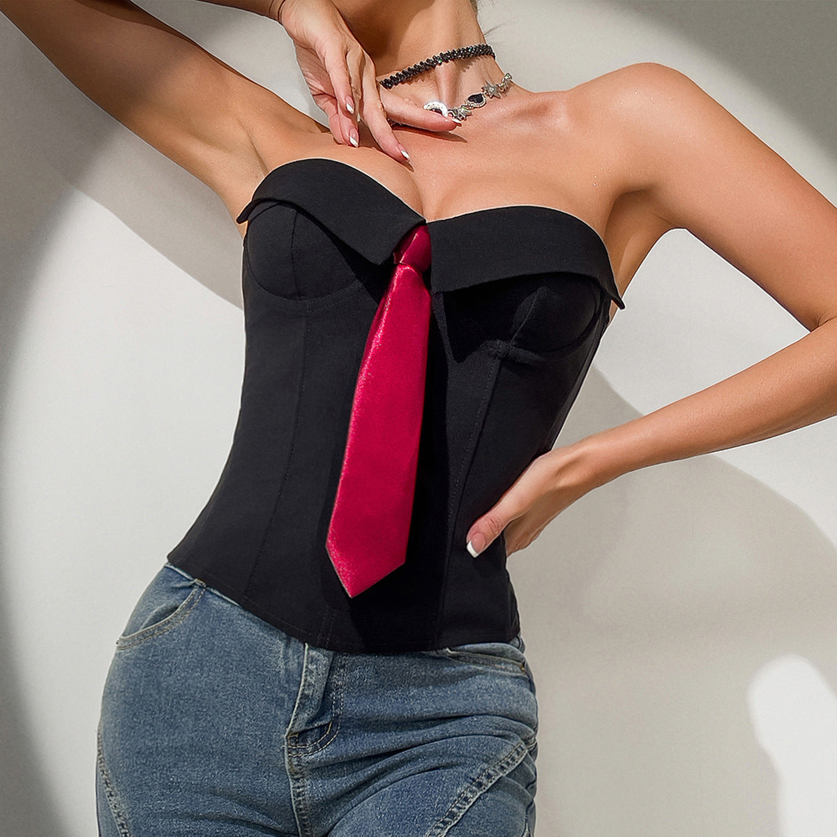Trendsi Y2K bandeau top black corset style strapless with red tie accent worn with high rise jeans