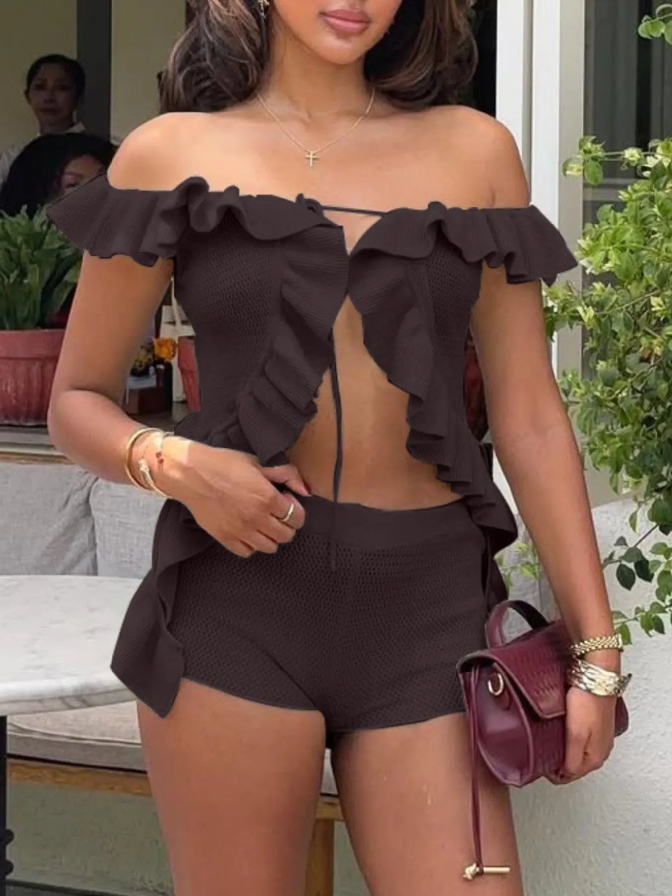 Trendsi Off-Shoulder Ruffle Top in black with matching shorts worn by a woman outdoors