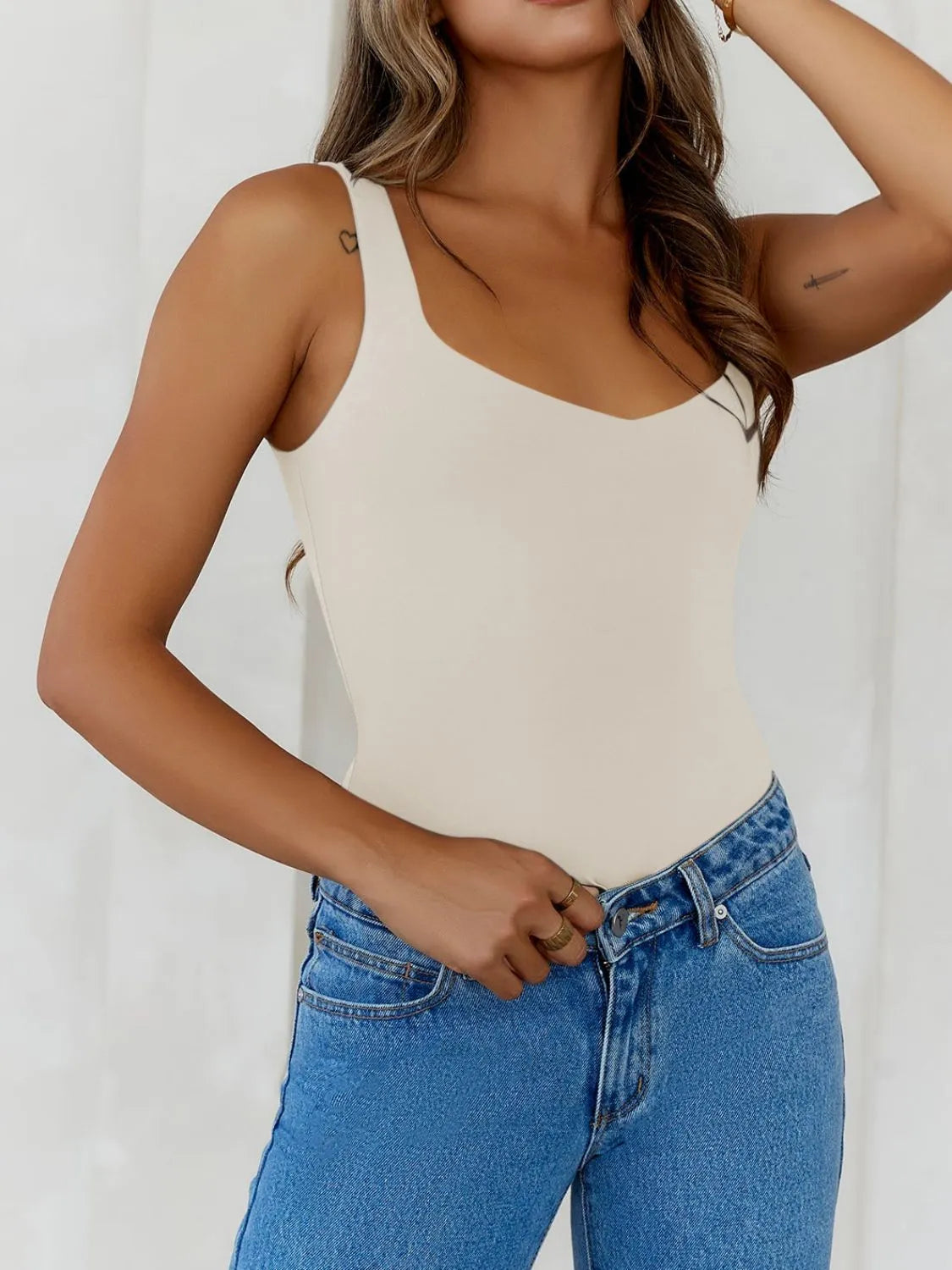 Trendsi V-Neck Tank Top in beige worn with high-waisted jeans for a stylish casual look