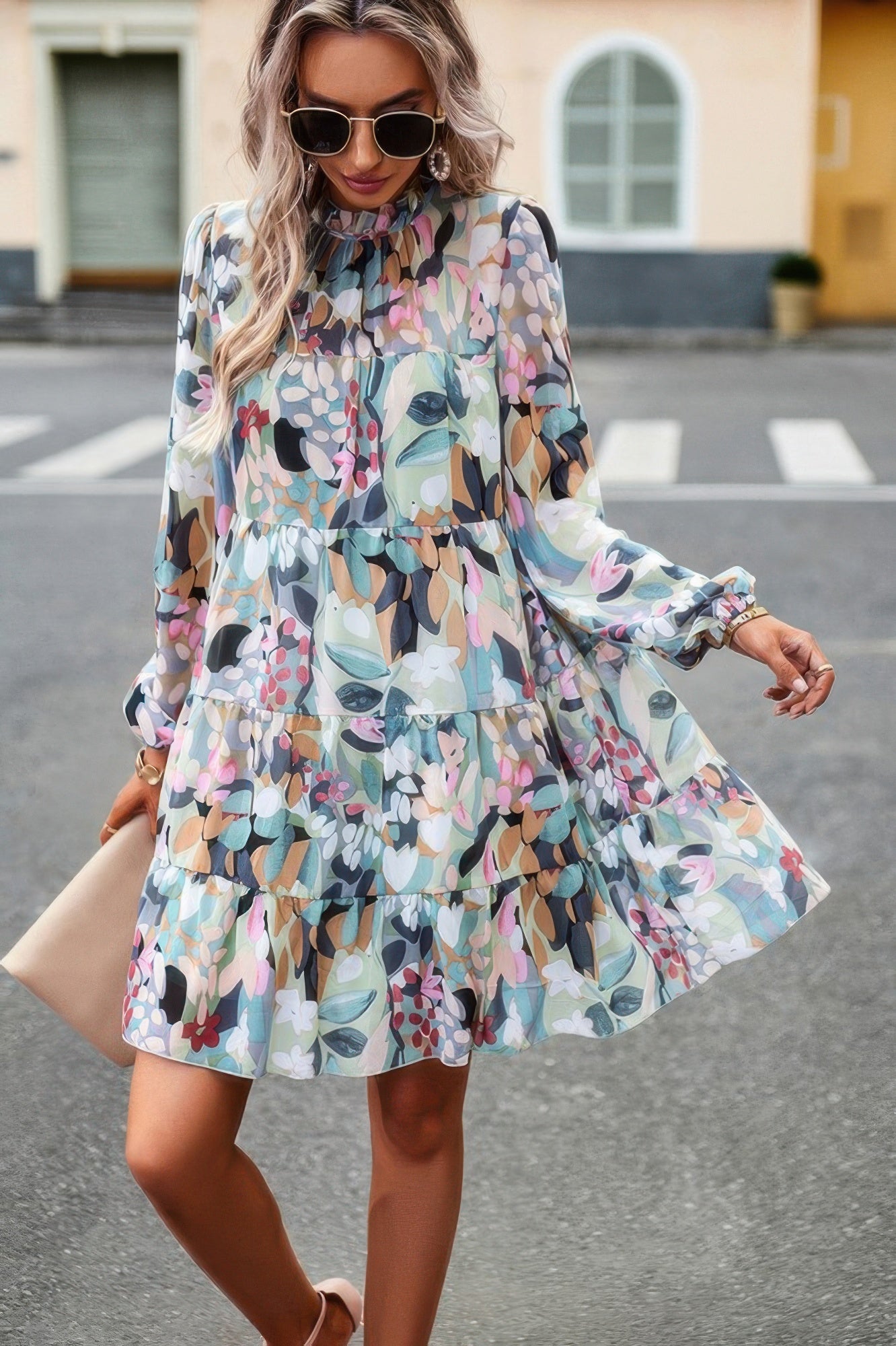 CCWHOLESALECLOTHING model wearing an abstract print tiered dress with long sleeves ruffle neck and pastel floral pattern