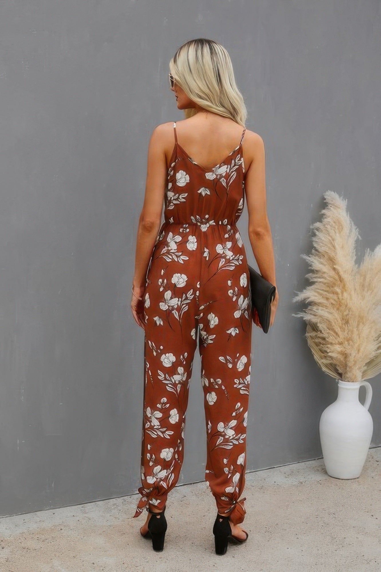 CCWHOLESALECLOTHING brown floral v neck spaghetti strap jumpsuit back view with tie ankles black clutch