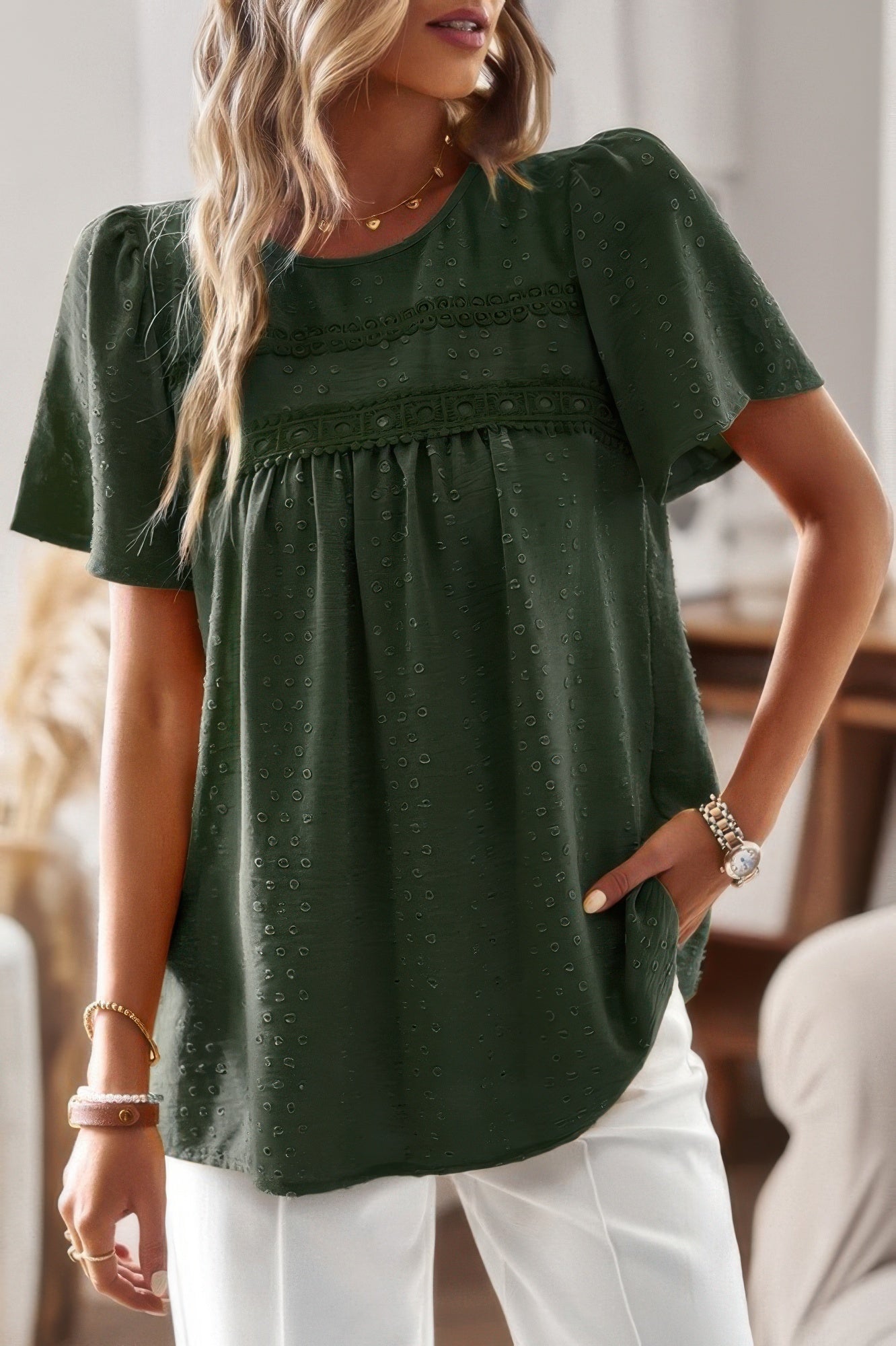 Woman wearing plus size solid short sleeve top in dark green with lace yoke gathered front and relaxed fit