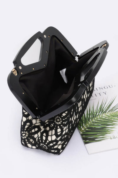 Black crochet wood frame clutch with cream lining and geometric floral crochet pattern showing open interior and top handles