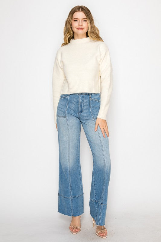Artemis Vintage model wearing eco-friendly palazzo jeans for women high waist light wash with seam patch details and cream sweater