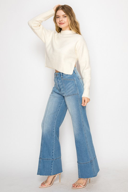 Artemis Vintage model wearing high waist light wash eco-friendly palazzo jeans for women with cropped cream sweater and heels