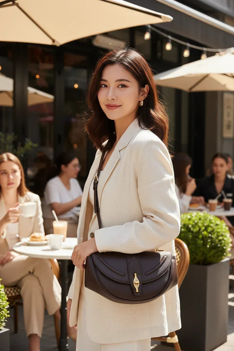 Beautiful Asian model with vintage saddle shoulder bag at outdoor cafe - half body shot