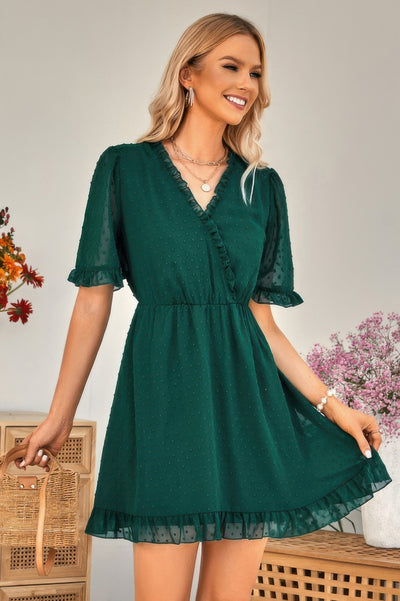 Model wearing emerald green swiss dot ruffle midi dress with V neck elastic waist ruffle hem and flutter sleeves
