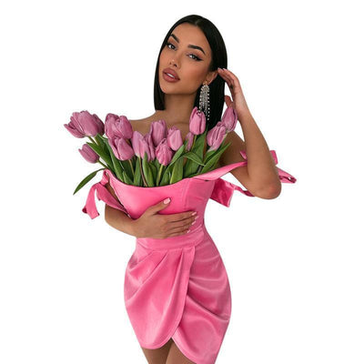 Trendsi Halter Mini Dress pink satin cocktail mini dress with draped tulip skirt worn by model holding pink tulip bouquet