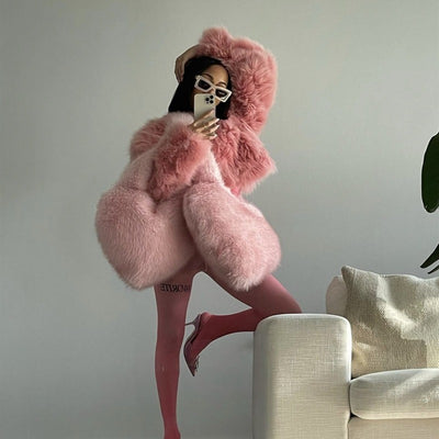 Trendsi Heart Messenger Bag in blush pink styled on model with oversized faux fur coat and pink tights