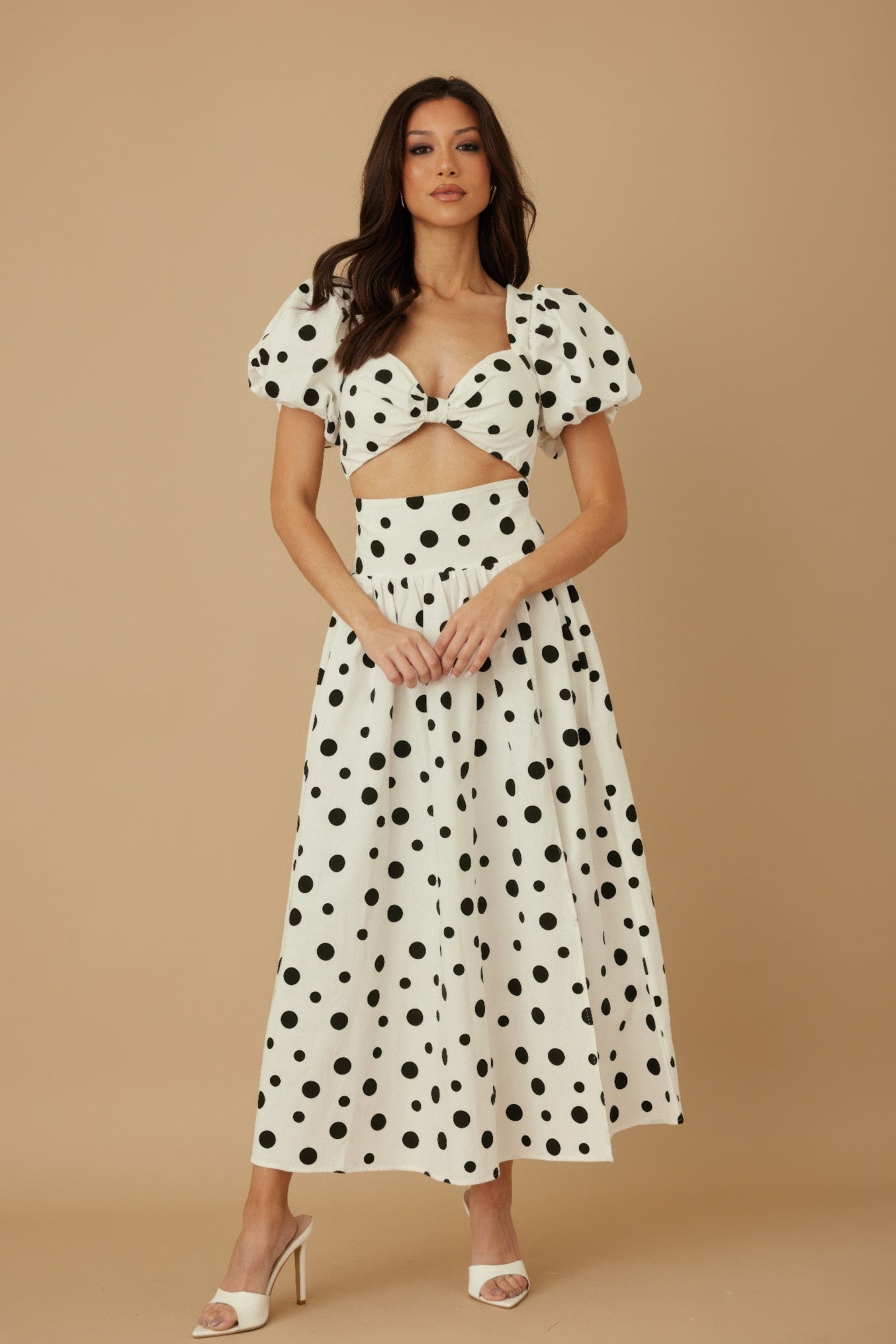 Model wearing CCWHOLESALECLOTHING polka dot two piece set white midi skirt puff sleeve crop top with front cutout