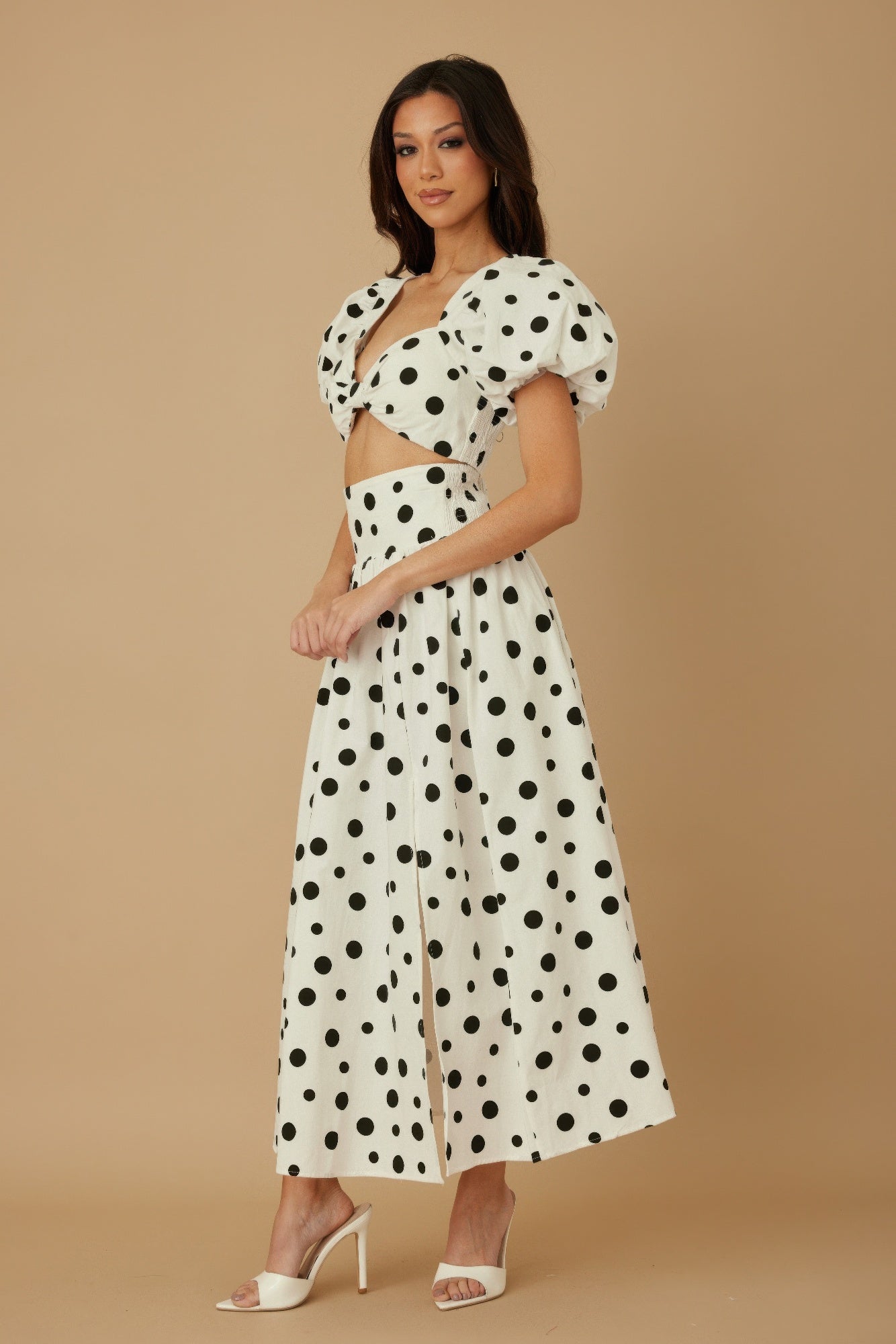 Model wearing CCWHOLESALECLOTHING white polka dot two piece set with puff sleeves cropped top and wide leg pants