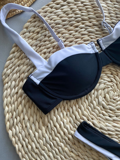 Trendsi black and white contrast bikini top with adjustable straps laid on woven mat