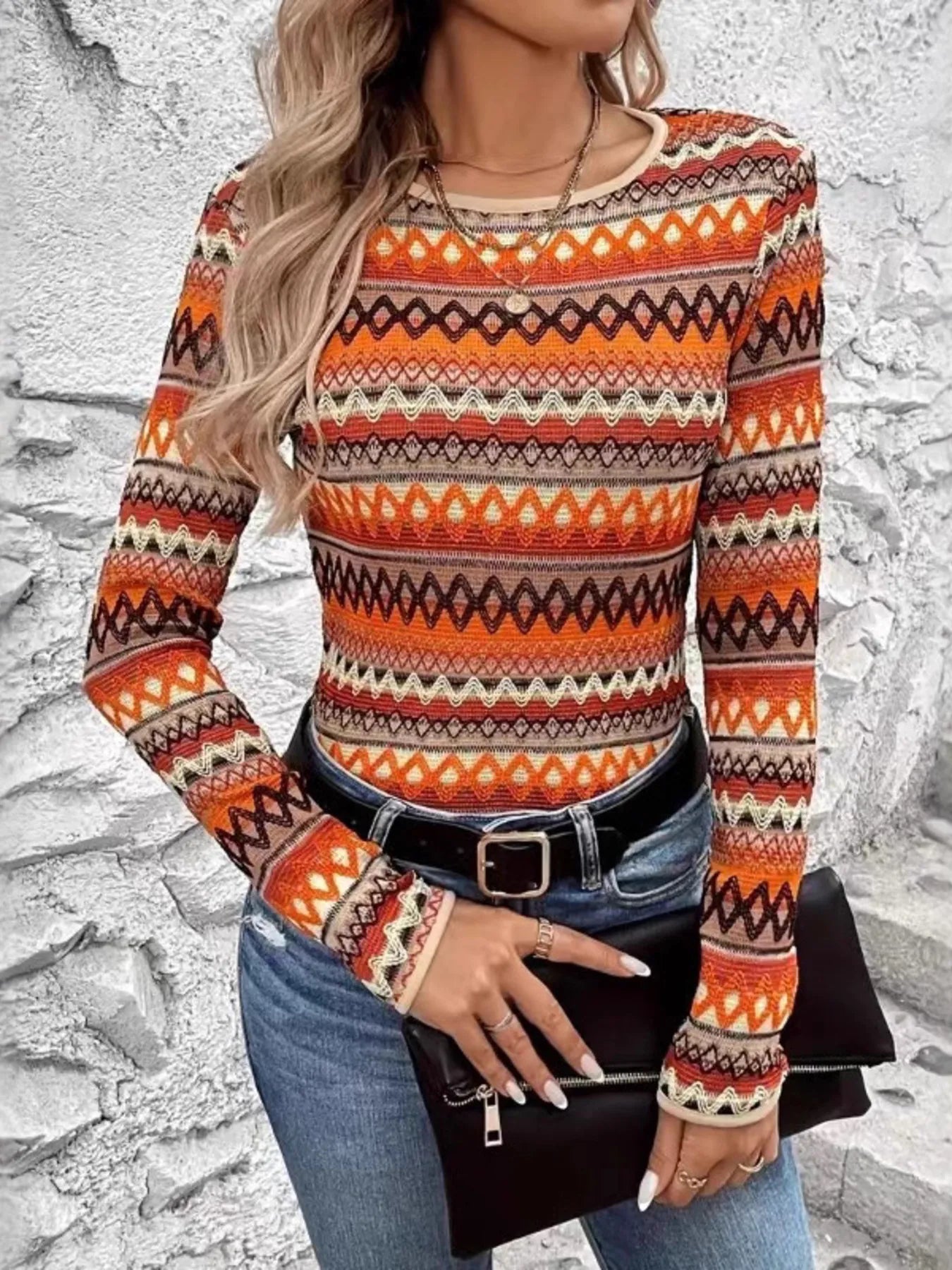 Trendsi fitted orange geometric Long Sleeve T-Shirt tucked into high waisted jeans with black belt and clutch