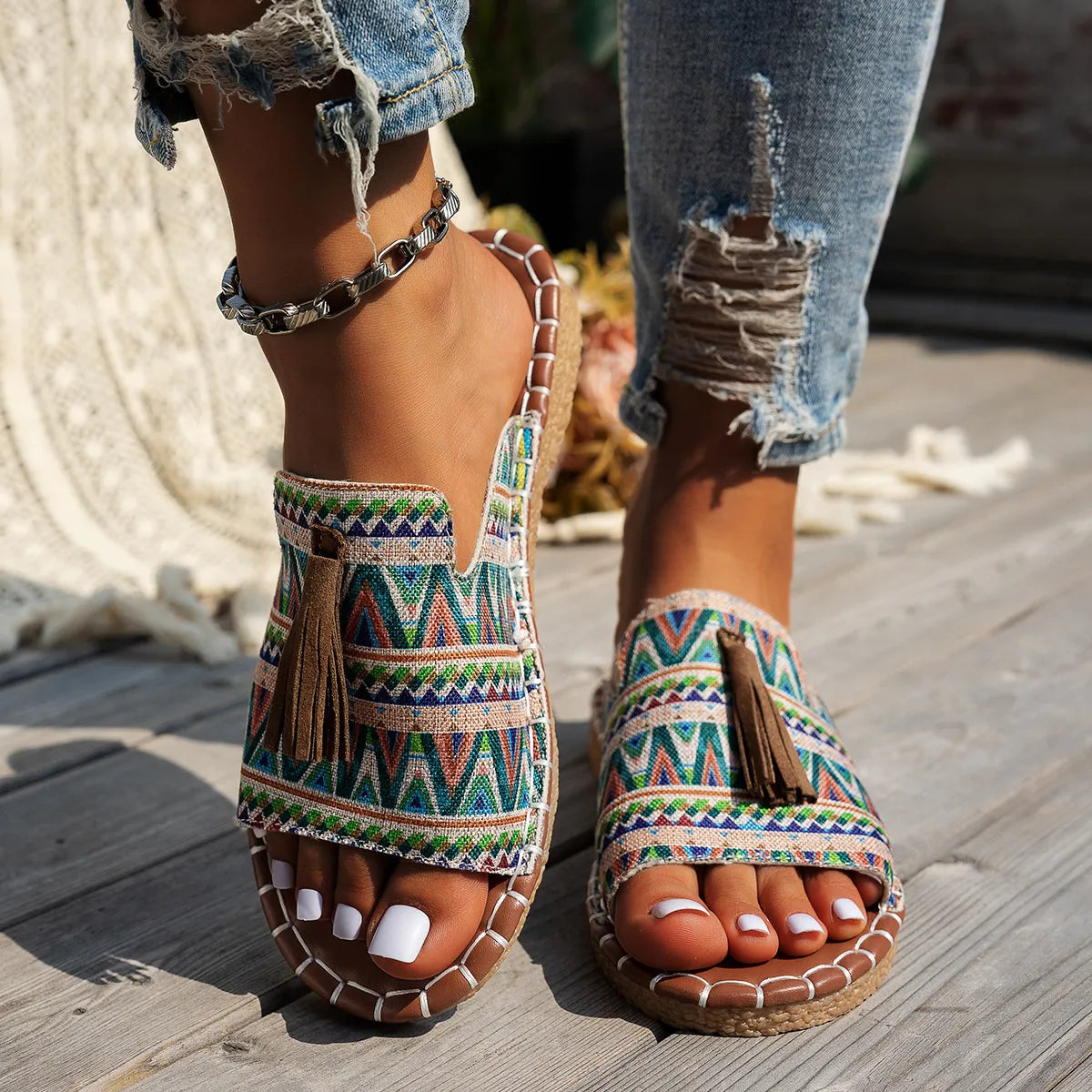 Trendsi Boho Tassel Slide Sandals with colorful geometric pattern and brown tassels on wooden deck