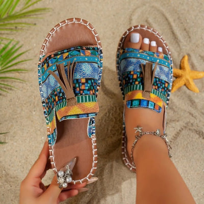 Trendsi Boho Tassel Slide Sandals with colorful patterned straps and brown footbed worn on sandy beach