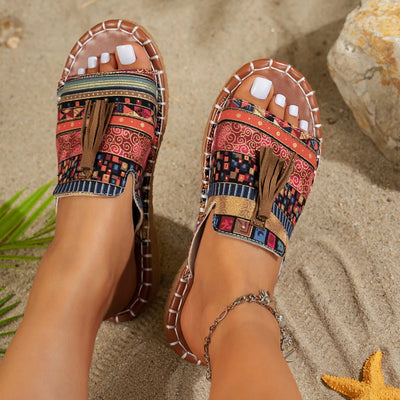Trendsi Boho Tassel Slide Sandals with colorful patterned straps worn on feet at the beach