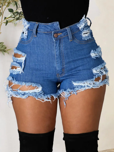 Women's distressed denim shorts high waist frayed hem ripped blue denim on model with black top and thigh high boots