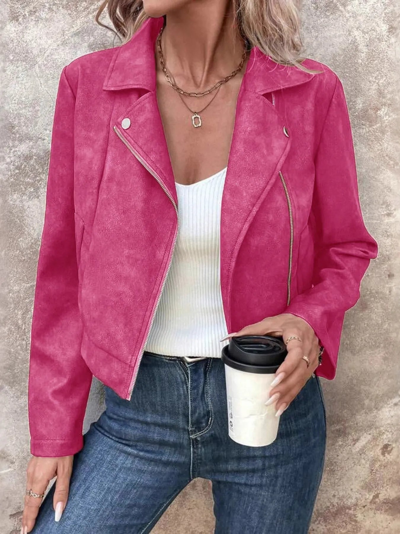 Trendsi women's suede moto jacket in bright pink on model wearing white ribbed tank and jeans holding coffee cup