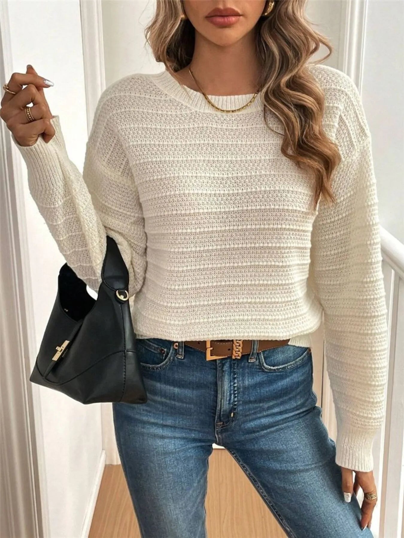 Trendsi Bow-Back Knit Top cream textured cropped sweater with long sleeves styled with jeans and black bag