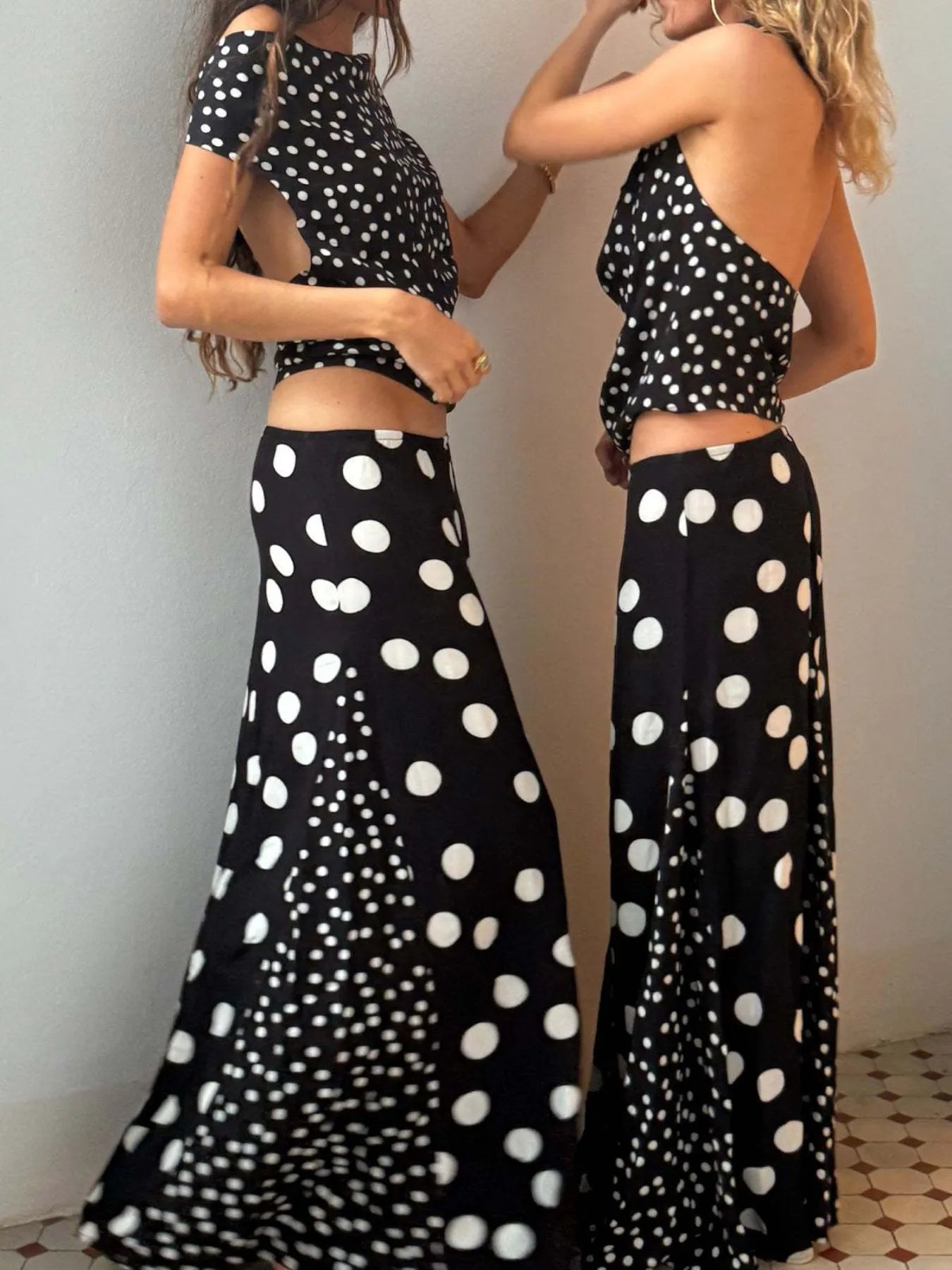Two models in Trendsi Top and Maxi Skirt Set black and white polka dots crop tops with open backs and flowing skirts