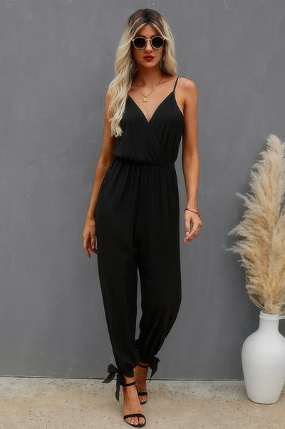Model in black V neck cami jumpsuit with ankle ties and elastic waist photographed for floral print cami jumpsuit listing