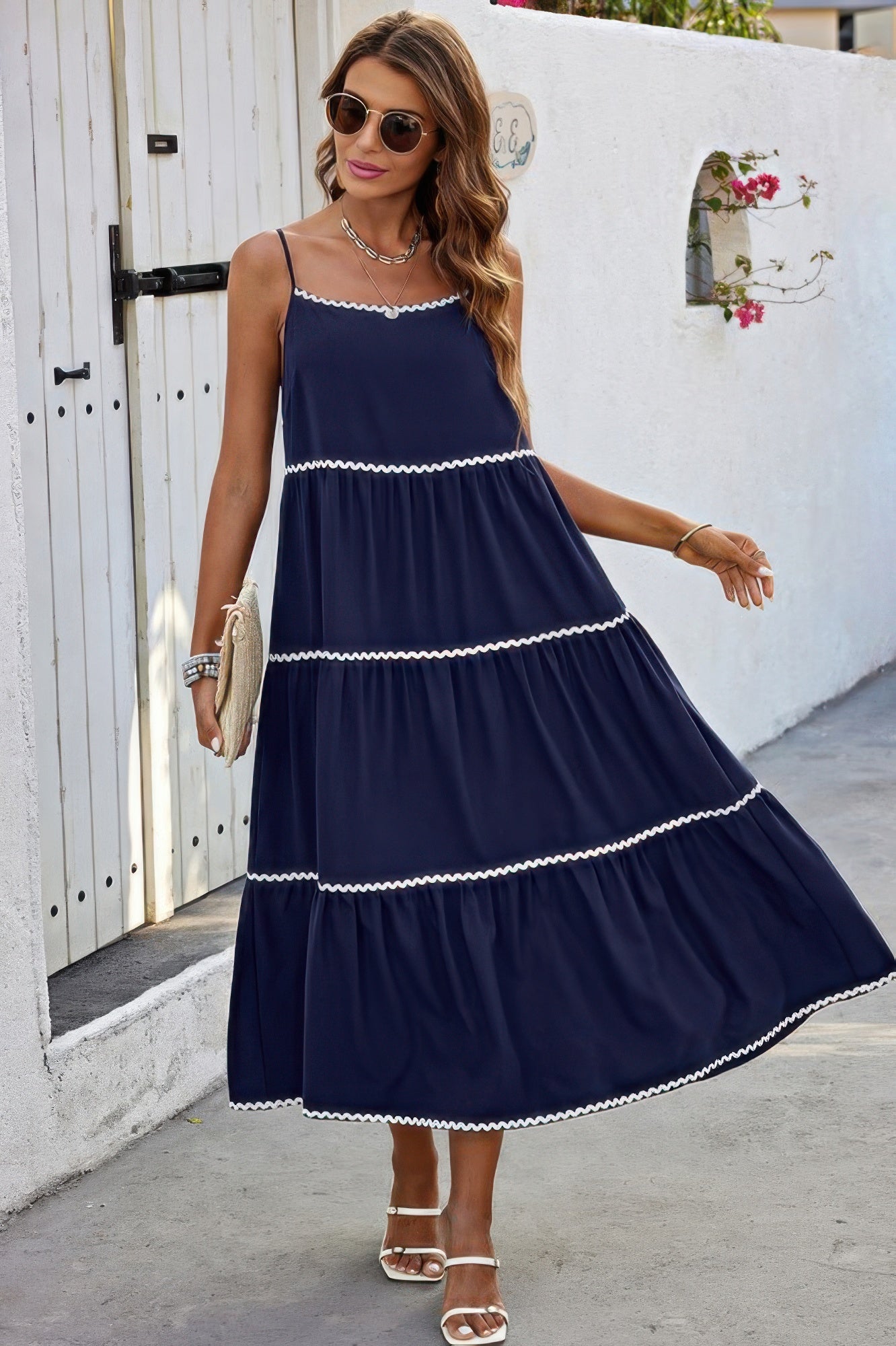 Woman wearing navy tiered A Line Ankle Dress with white scalloped trim spaghetti straps sandals and clutch