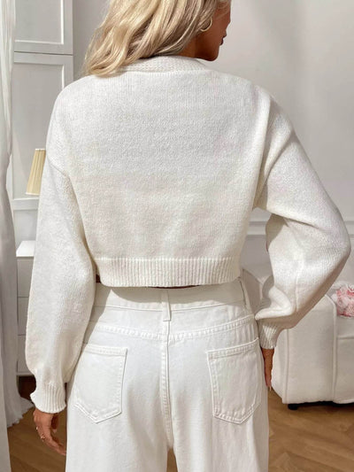 Back view of a white Cropped Button-Up Cardigan featuring a cozy knit design, paired with high-waisted jeans